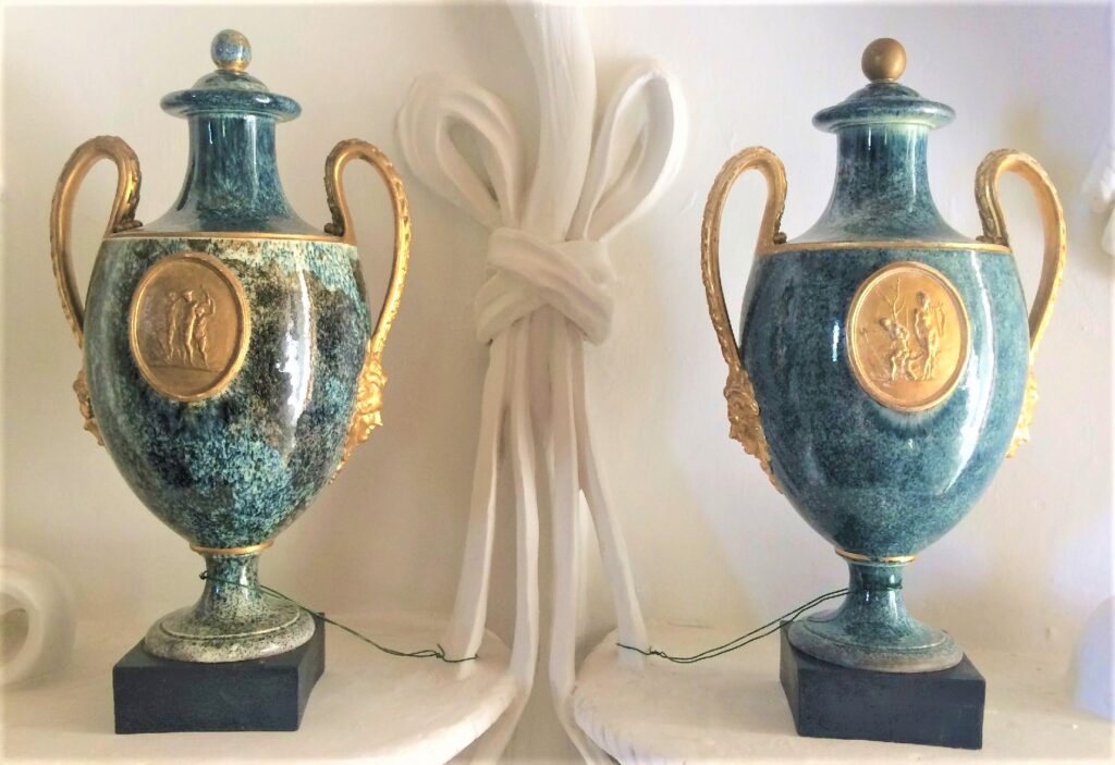 Two blue-green variegated vases with gold-colored details.