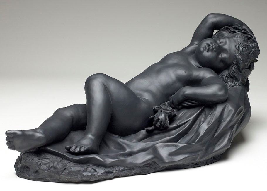Grayish-black sculpture of a sleeping baby.