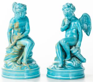 Two turquoise-colored seated figures.