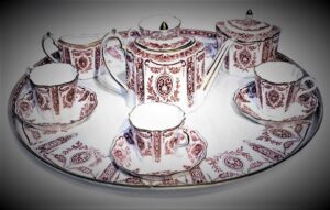 Tea set, white with ornate deep red vegetal patterns.